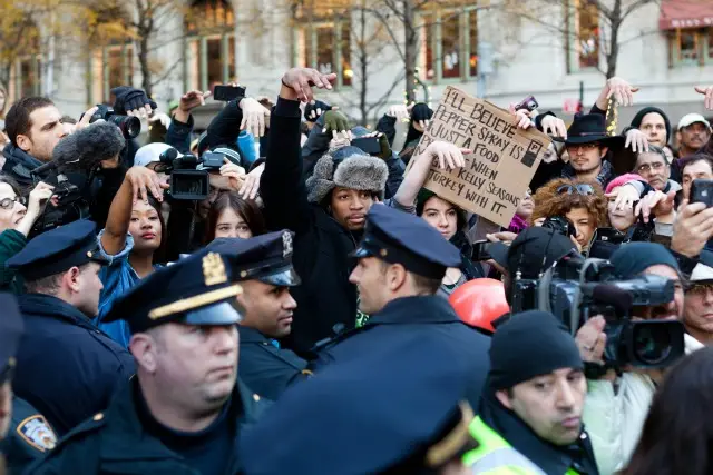 Occupy Wall Street protestors show they disapprove of police demanding that drums not be played in Zuccotti park due to a supposed noise complaint from nearby residents on Thanksgiving day, 